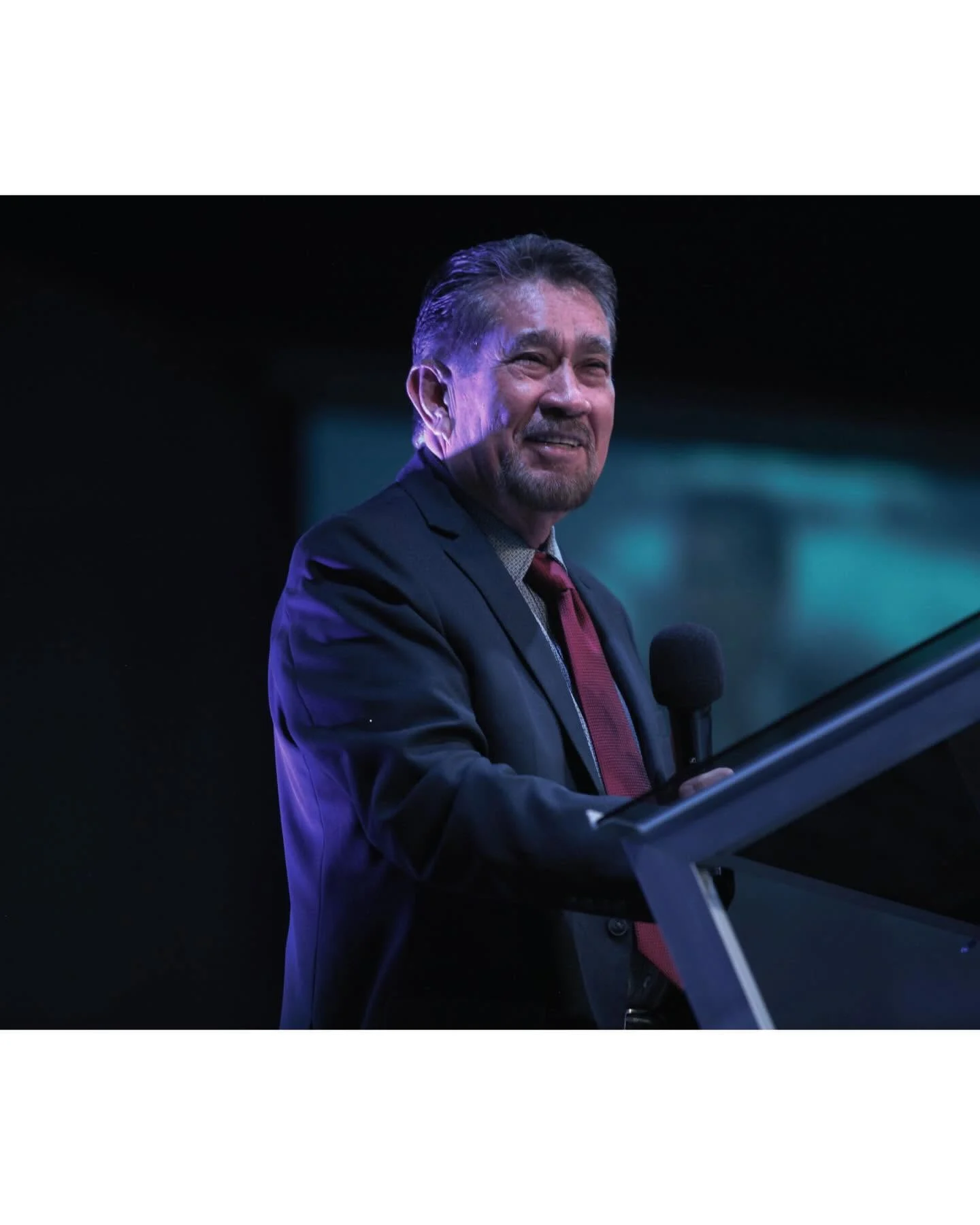 A Nuevo Pacto leader ministering from the platform during a service