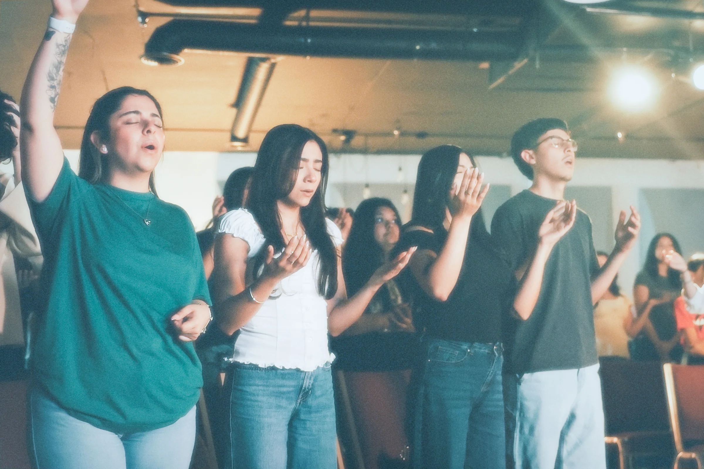 Joven adulto de The Warehouse en un momento de oración