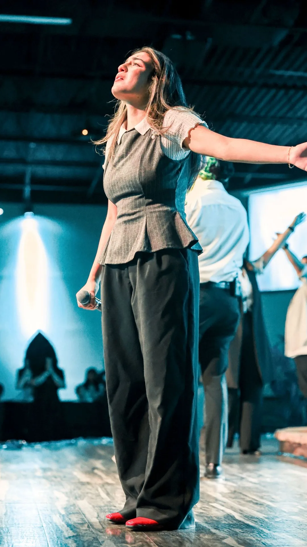 Mujer adorando durante un servicio en Iglesia Nuevo Pacto